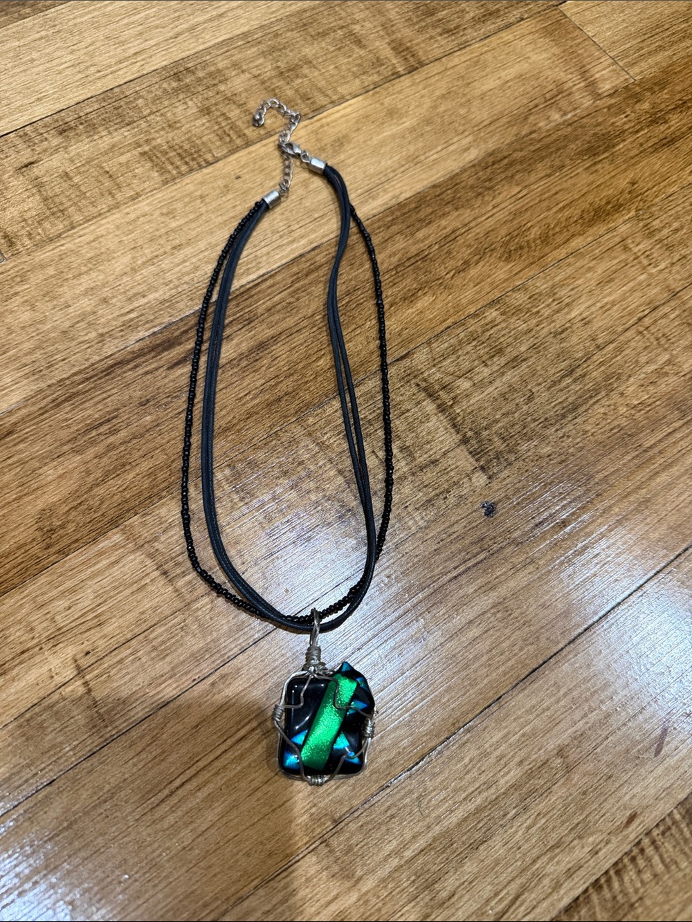 Multi-Strand Black Necklace with Iridescent Green-Blue Pendant